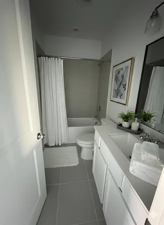 a bathroom with a granite countertop sink a toilet a mirror and shower