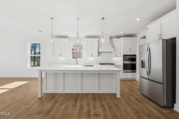 a kitchen with kitchen island granite countertop a sink a counter space appliances and cabinets