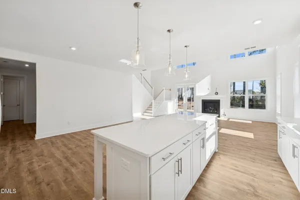 a view of an empty room with wooden floor and a fireplace