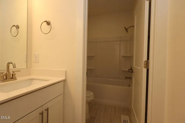 a view of a room with wooden floor and fan