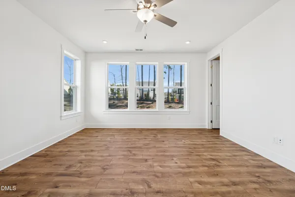 a living room with furniture and a bookshelf with wooden floor