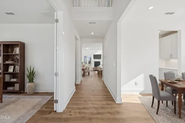 a view of a hallway with wooden floor and a living room