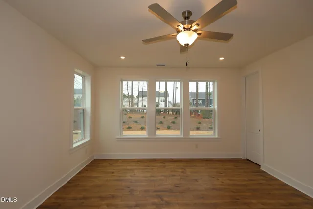 a view of an empty room with a window and a fan
