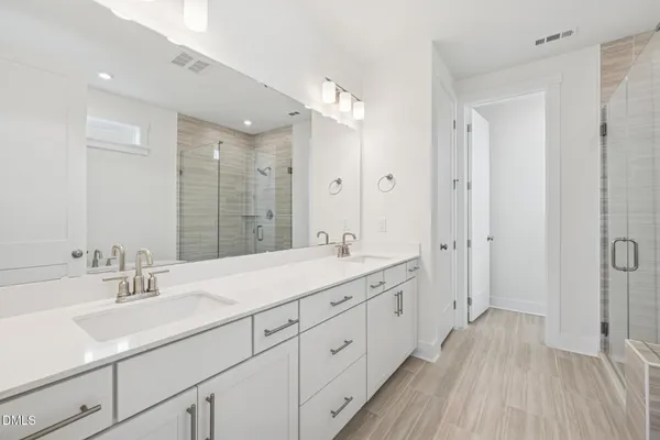 a bathroom with a sink vanity granite tub shower and a mirror