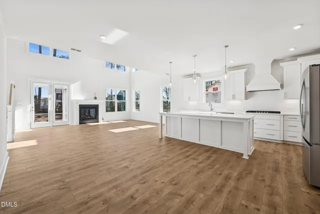 a large kitchen with stainless steel appliances kitchen island granite countertop a large cabinets a sink and a stove