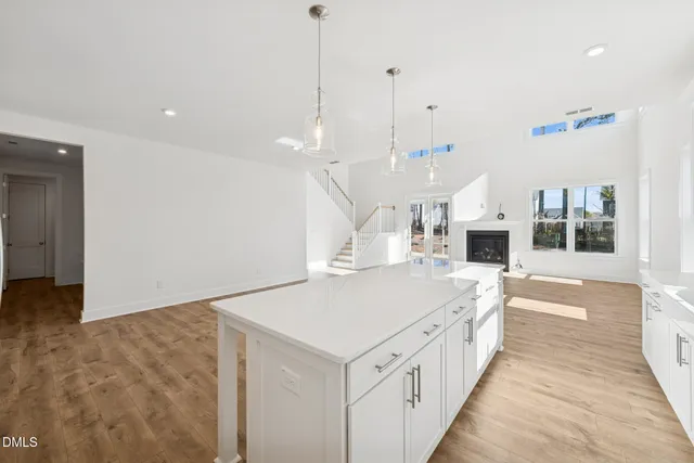 a large white kitchen with a large stove a sink and kitchen island