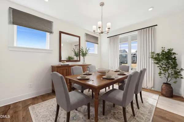 a view of a dining room with furniture wooden floor and chandelier