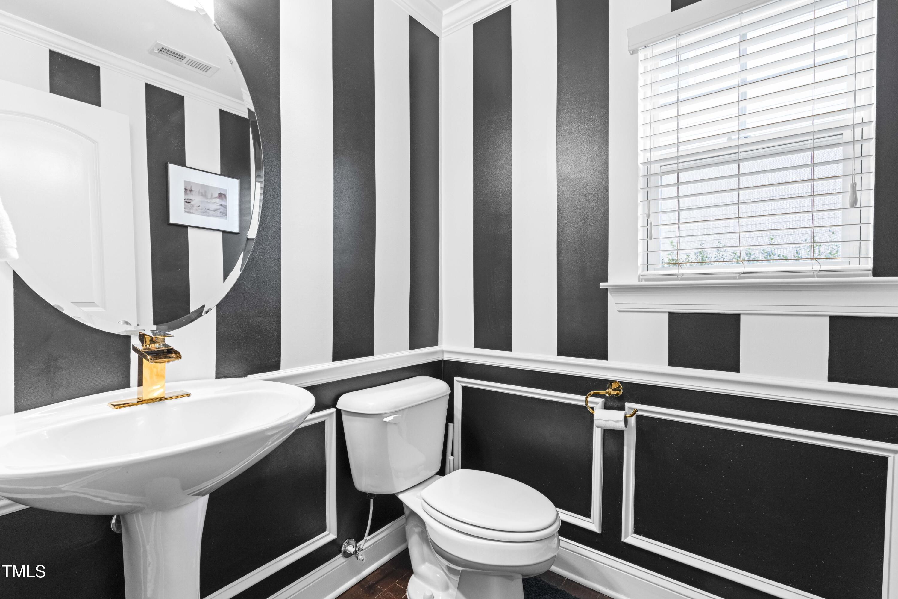 1805 Bodwin Lane Apex, NC 27502 - Photo 25 of 43 a bathroom with a toilet a sink and a mirror