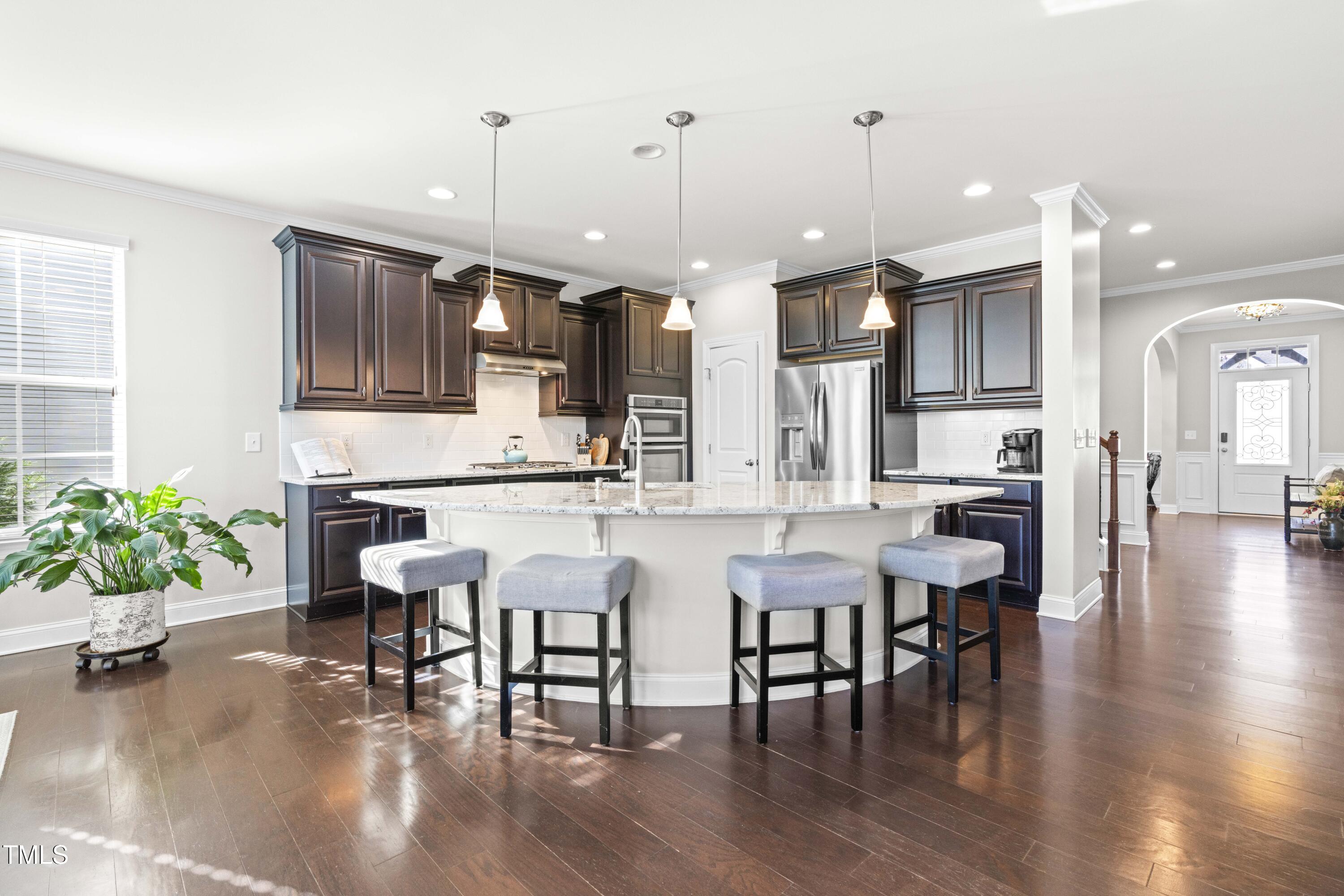 1805 Bodwin Lane Apex, NC 27502 - Photo 7 of 43 a kitchen with stainless steel appliances a dining table chairs stove and kitchen view