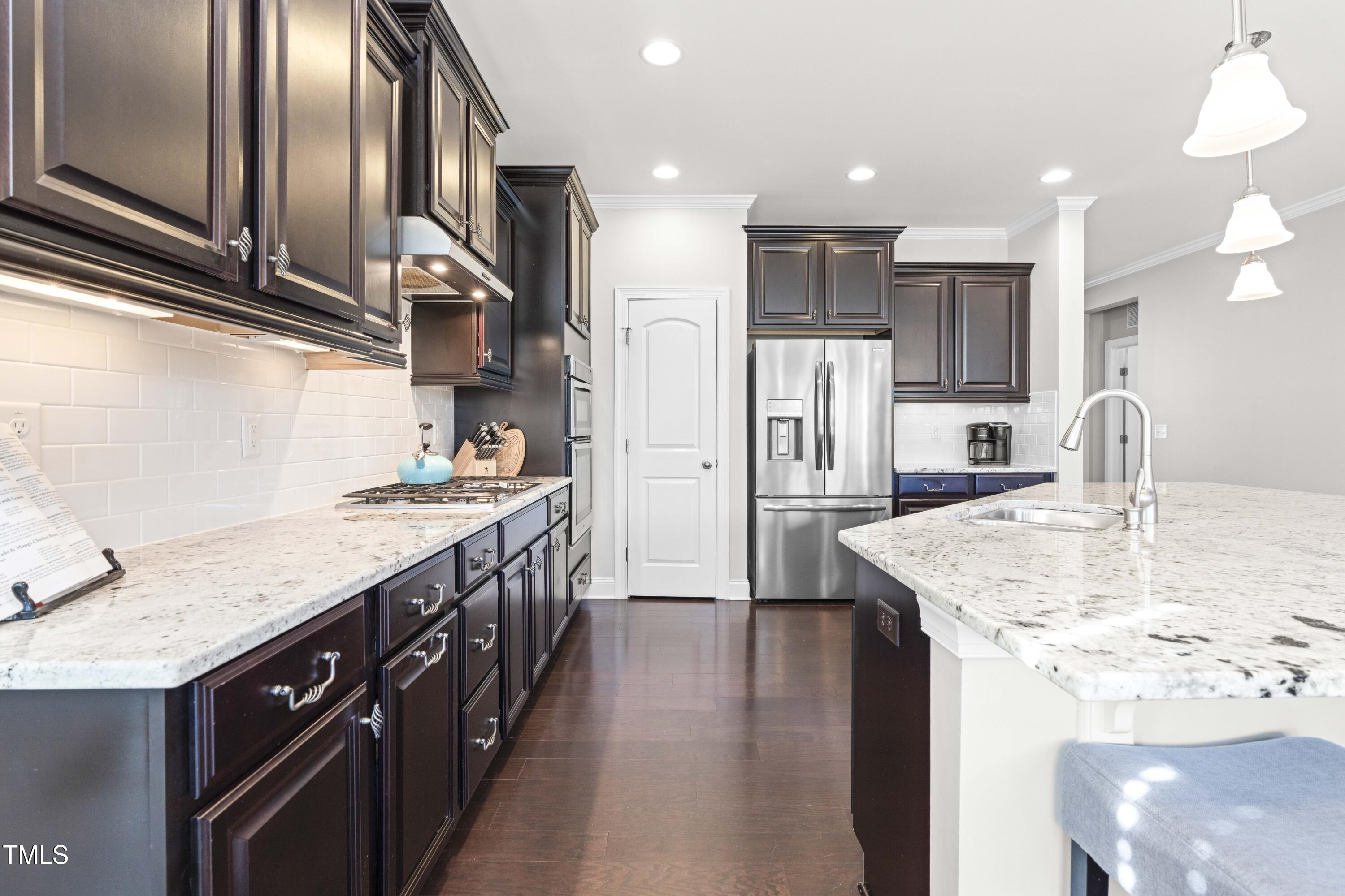 1805 Bodwin Lane Apex, NC 27502 - Photo 8 of 43 a kitchen with stainless steel appliances granite countertop a sink stove and refrigerator