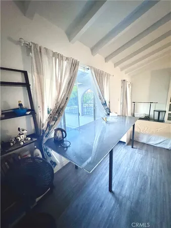 a living room with couches and a dining table with wooden floor