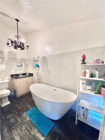 a white bath tub sitting next to a white toilet and a sink
