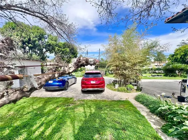 a park view with a table and chairs under an umbrella