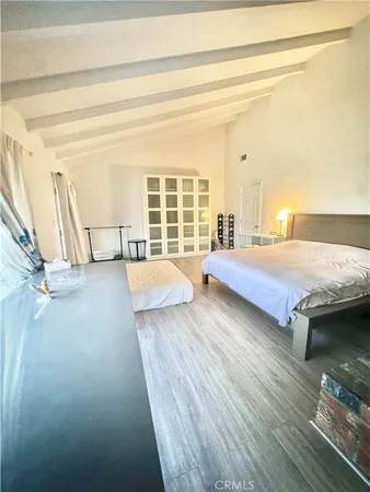a bedroom with a bed and wooden floor