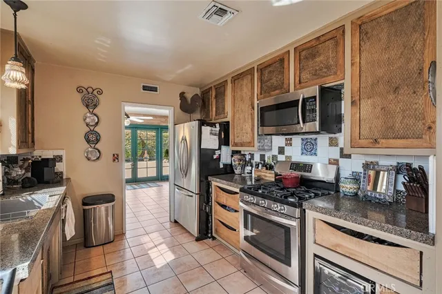 a kitchen with stainless steel appliances granite countertop a stove microwave and sink