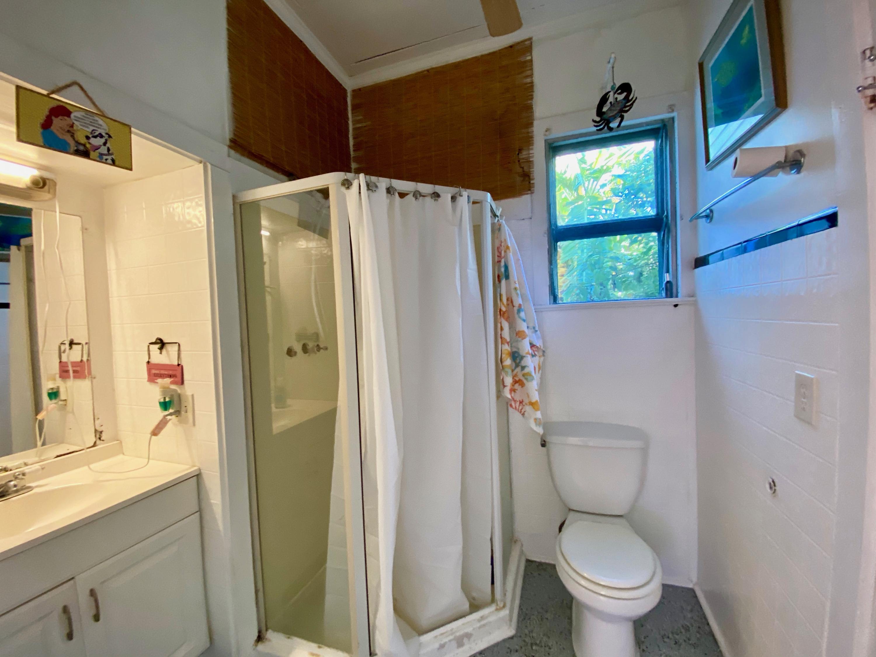 1438 Virginia Street Key West, FL 33040 - Photo 22 of 37 a white toilet sitting next to a bathroom sink and a window