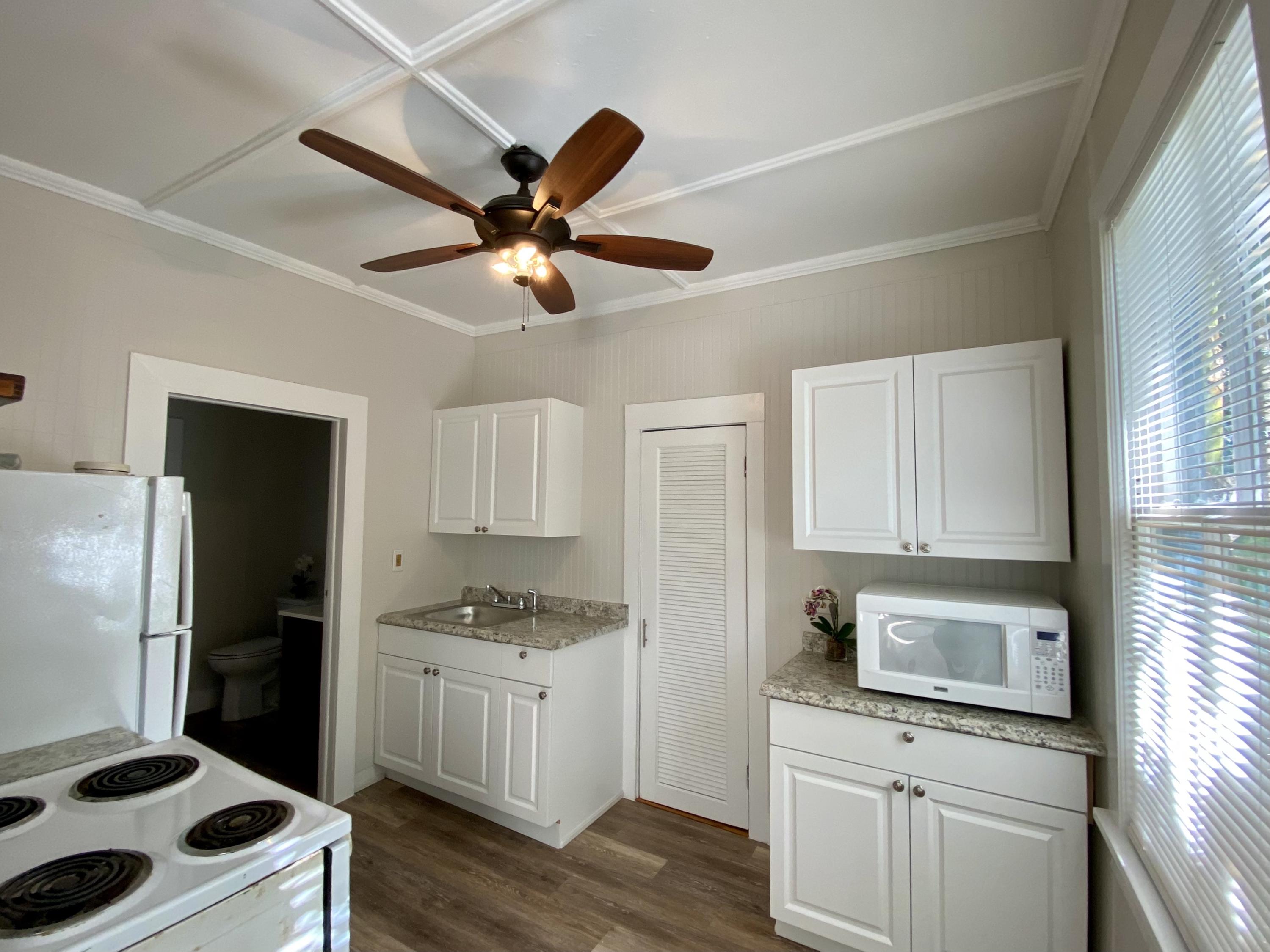 1438 Virginia Street Key West, FL 33040 - Photo 6 of 37 a kitchen with granite countertop a sink cabinets stainless steel appliances and a window