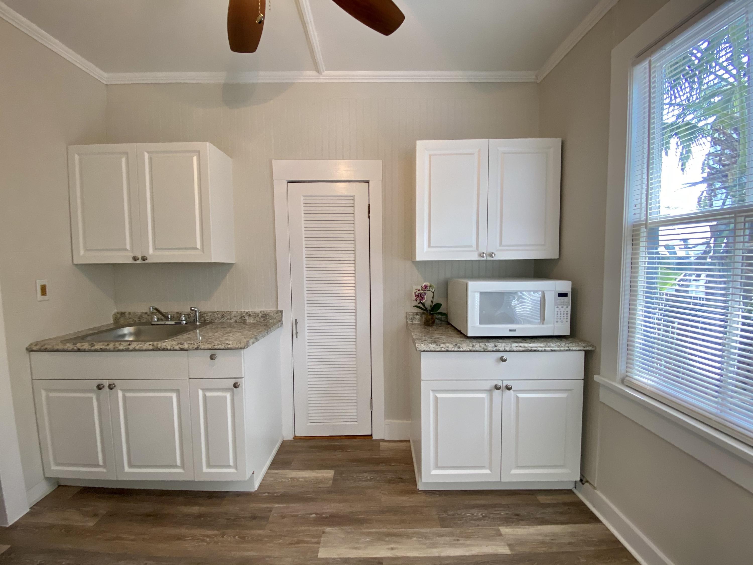 1438 Virginia Street Key West, FL 33040 - Photo 7 of 37 a kitchen with stainless steel appliances granite countertop a stove a sink and a white cabinets