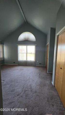 an empty room with windows and closet