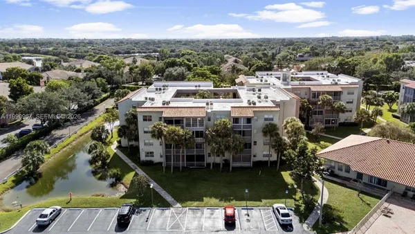 an aerial view of a house with a garden and lake view