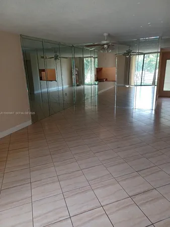 an empty room with wooden floor and chandelier