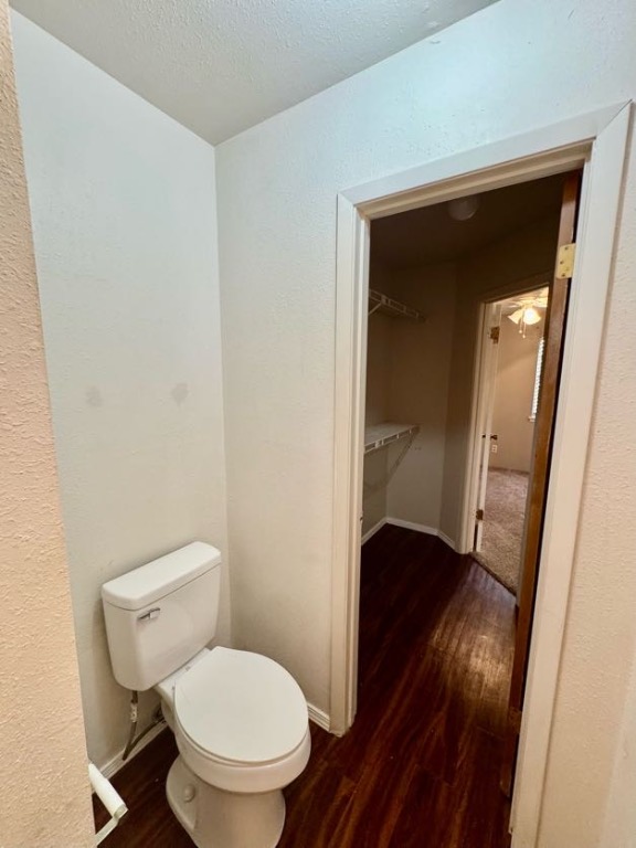 1305 West Villa Maria Road, Unit F105 Bryan, TX 77801 - Photo 20 of 26 Half bathroom featuring dark wood-style flooring, a textured wall, and a textured ceiling