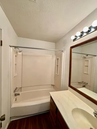 a bathroom with a tub sink and mirror