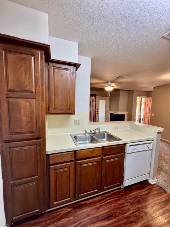 1305 West Villa Maria Road, Unit F105 Bryan, TX 77801 - Photo 26 of 26 Kitchen featuring light countertops, dishwasher, dark wood-style floors, a textured ceiling, and open floor plan