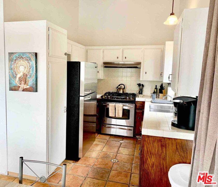 1152 1/2 North Ogden Drive West Hollywood, CA 90046 - Photo 5 of 12 a kitchen with stainless steel appliances a stove a refrigerator and cabinets
