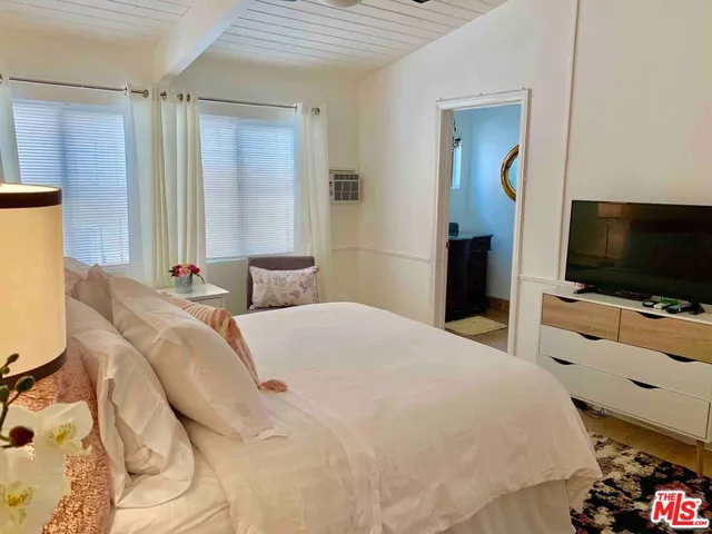 a bedroom with a bed and a flat screen tv