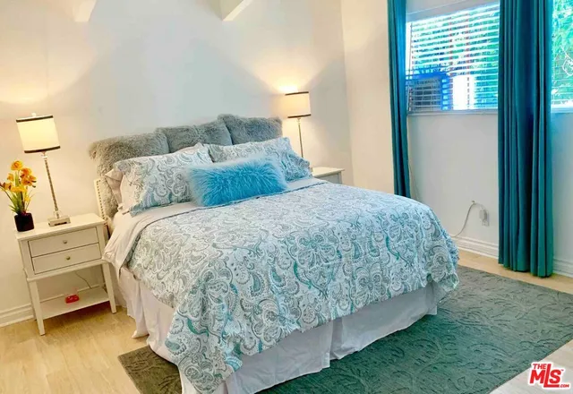 a bed sitting in a bedroom next to a window