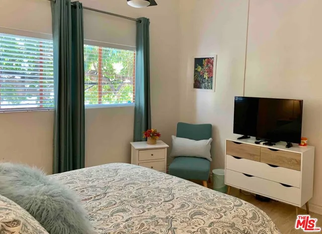 a bedroom with a bed and a flat screen tv