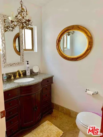 a bathroom with a toilet mirror and vanity
