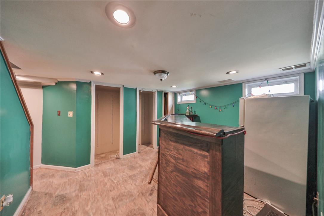 3050 Cornwall Road Bethlehem, PA 18017 - Photo 49 of 80 A well-lit basement with a bar, offering potential for recreation or additional living space.