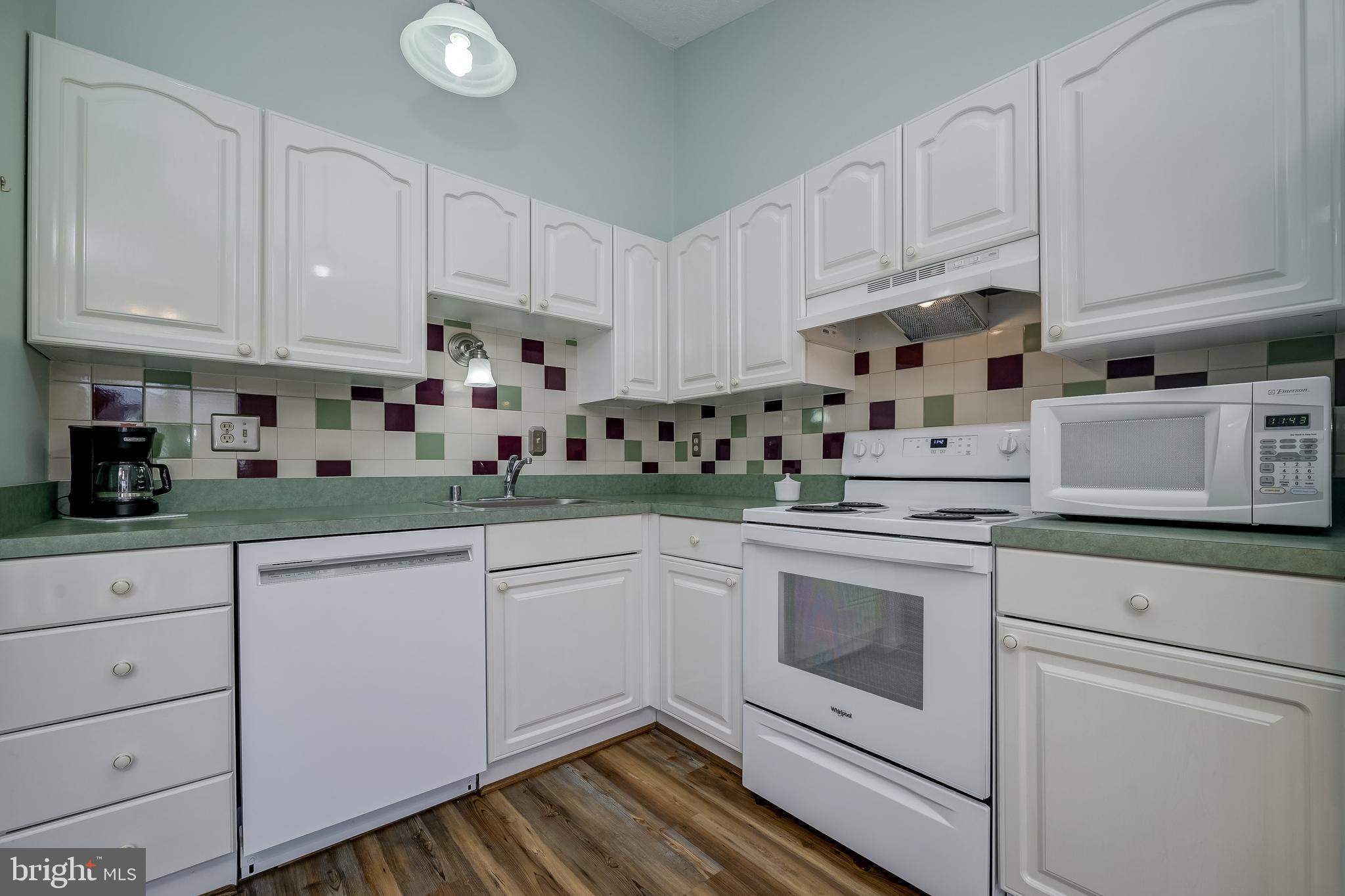 7179 Harp String Columbia, MD 21045 - Photo 11 of 27 a kitchen with white cabinets and white appliances