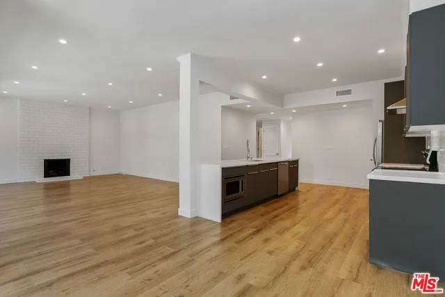 a view of empty room with wooden floor and fireplace