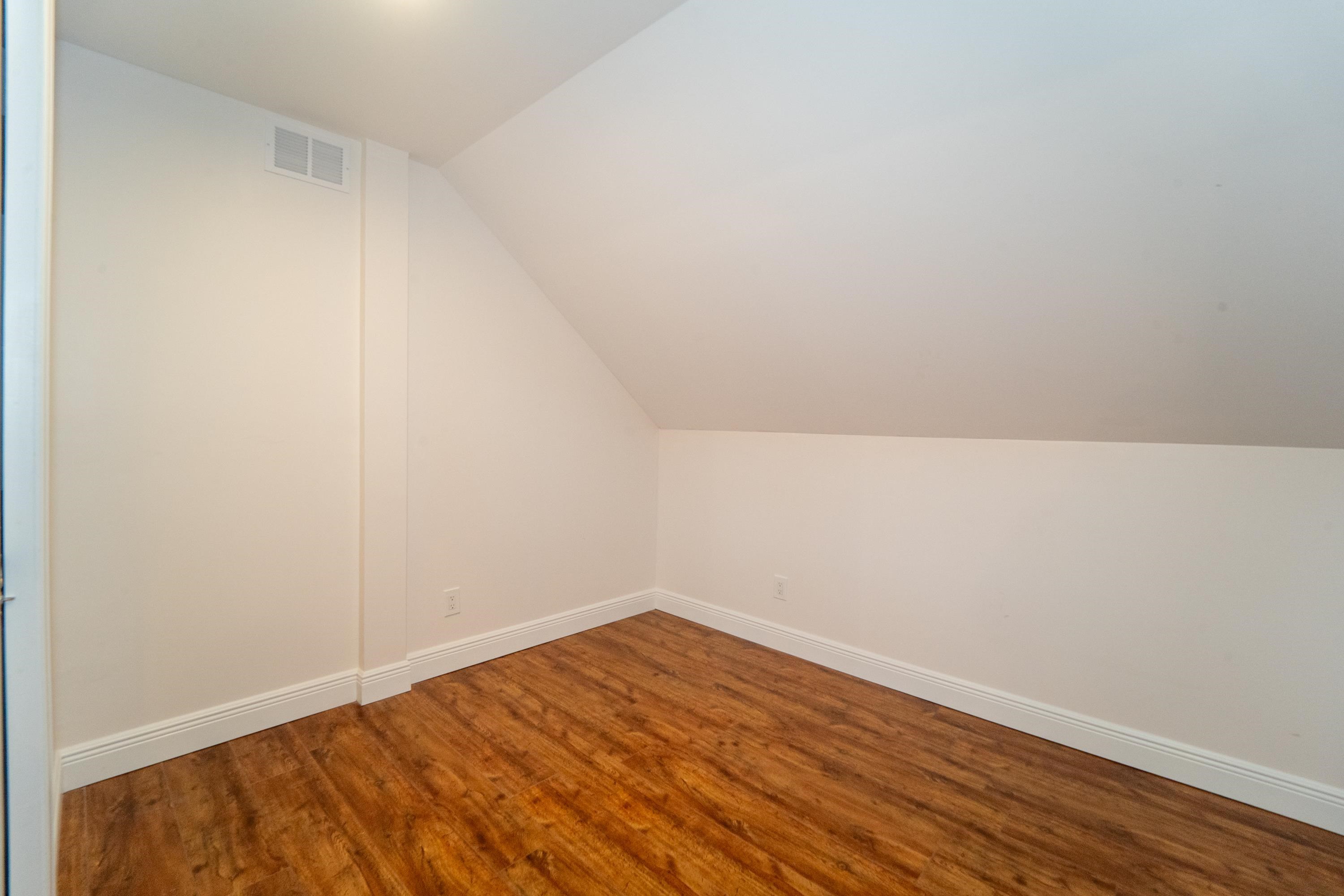 11 Aviles Street, Unit 3C St. Augustine, FL 32084 - Photo 12 of 24 Additional living space featuring wood finished floors and vaulted ceiling