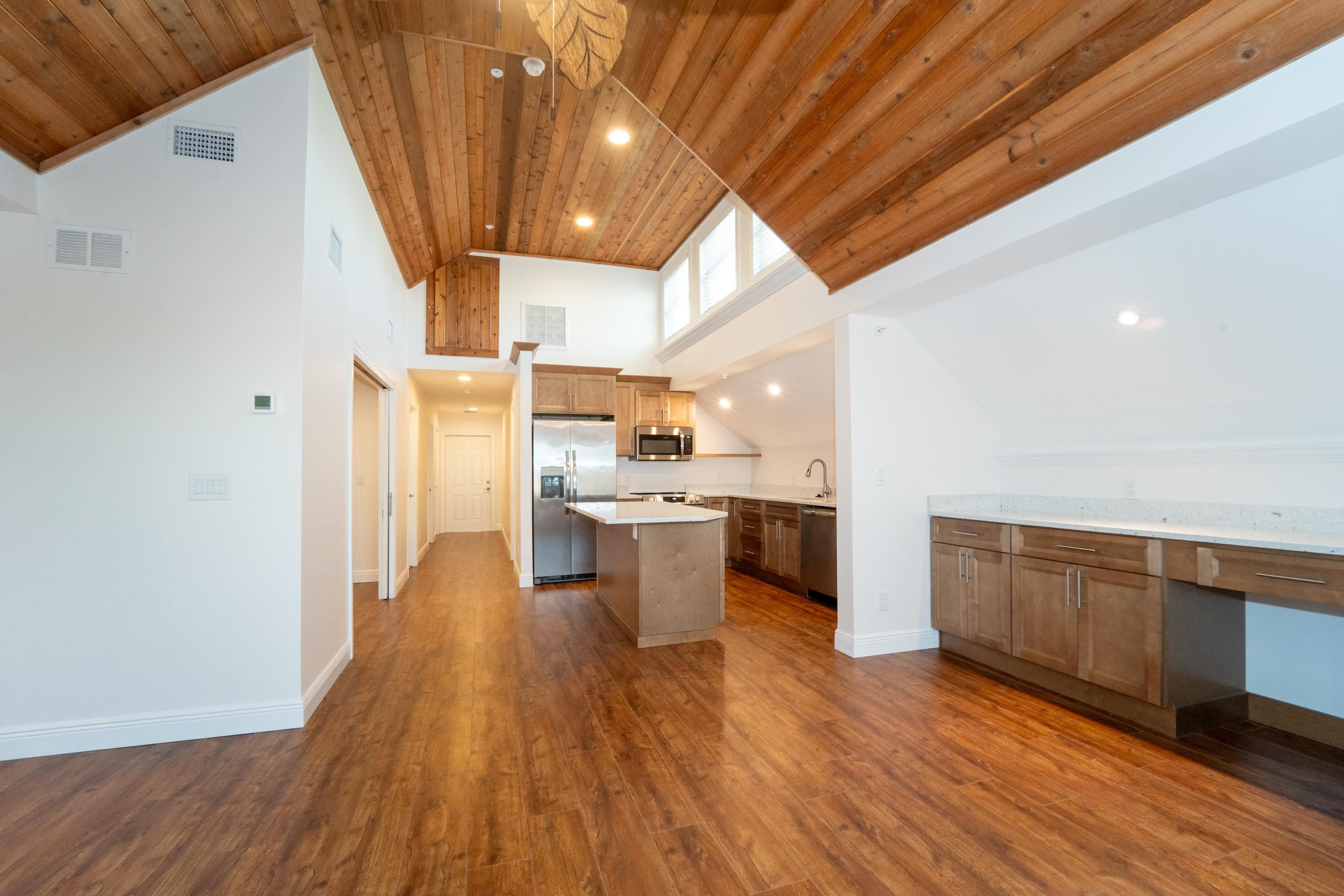11 Aviles Street, Unit 3C St. Augustine, FL 32084 - Photo 5 of 24 Kitchen featuring high vaulted ceiling, recessed lighting, dark wood finished floors, stainless steel appliances, and a center island