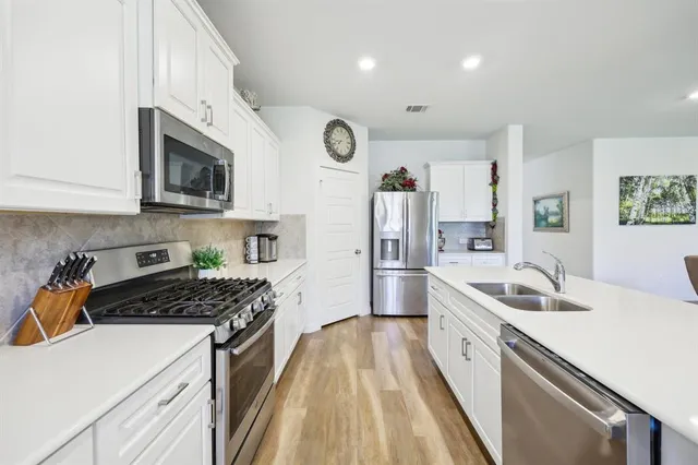 a kitchen with stainless steel appliances granite countertop a sink stove and refrigerator