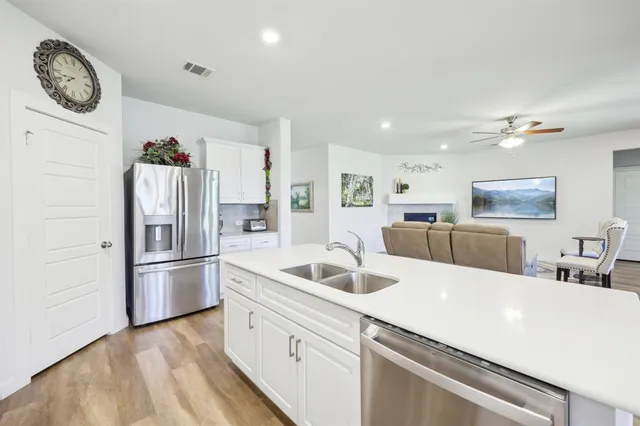 a kitchen with stainless steel appliances granite countertop a refrigerator and a sink