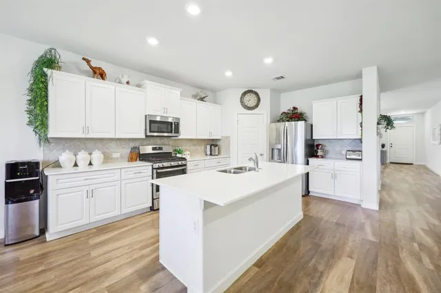 a kitchen with white cabinets and stainless steel appliances