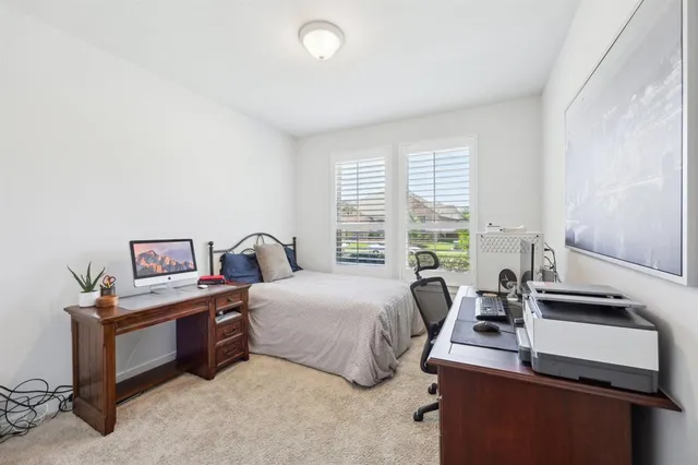 a bedroom with a bed and a large window