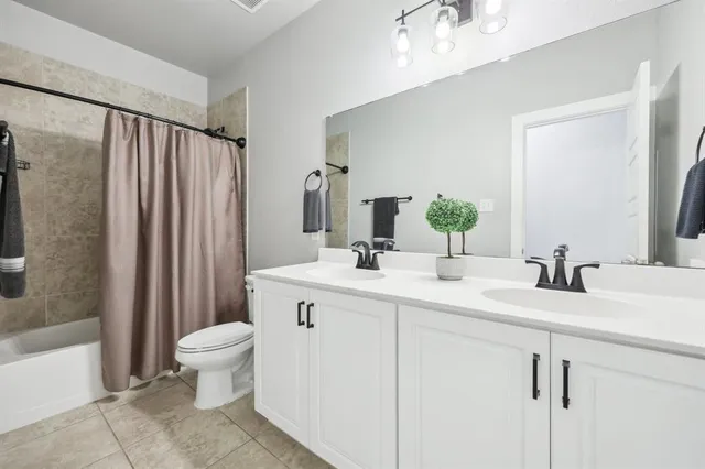 a bathroom with a double vanity sink toilet and shower