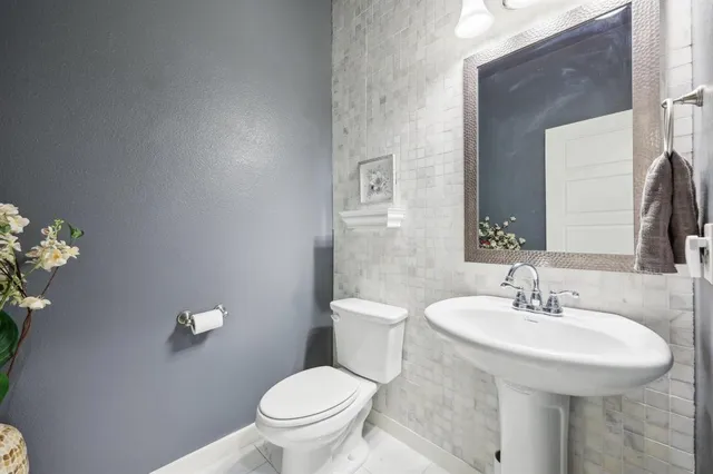 a bathroom with a sink a toilet and a mirror