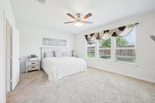 a spacious bedroom with a large bed and a large window
