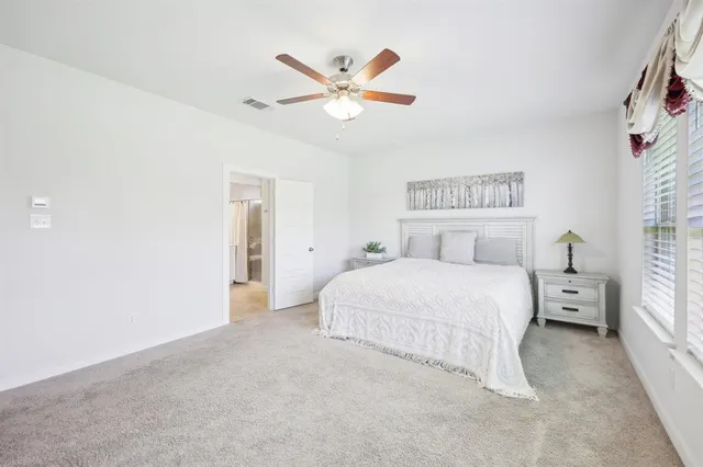 a bedroom with a large bed and a chandelier