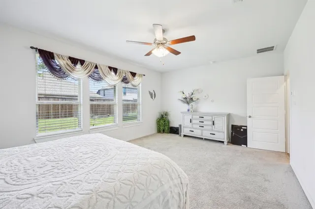 a spacious bedroom with a bed and a large window