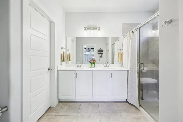 a bathroom with a shower sink and mirror