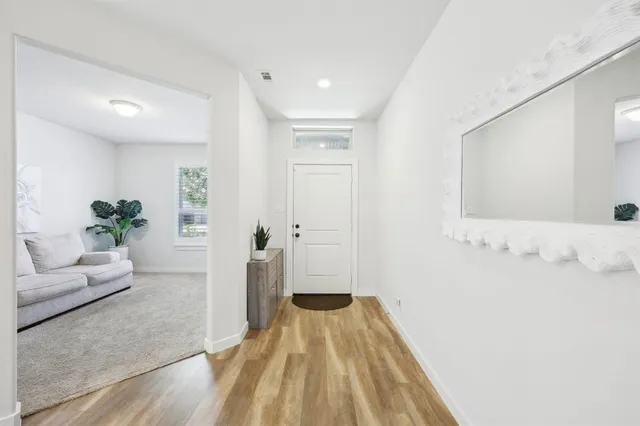 a view of a bedroom with wooden floor and furniture