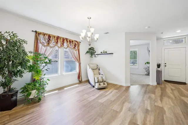 a view of a room with wooden floor potted plant and windows